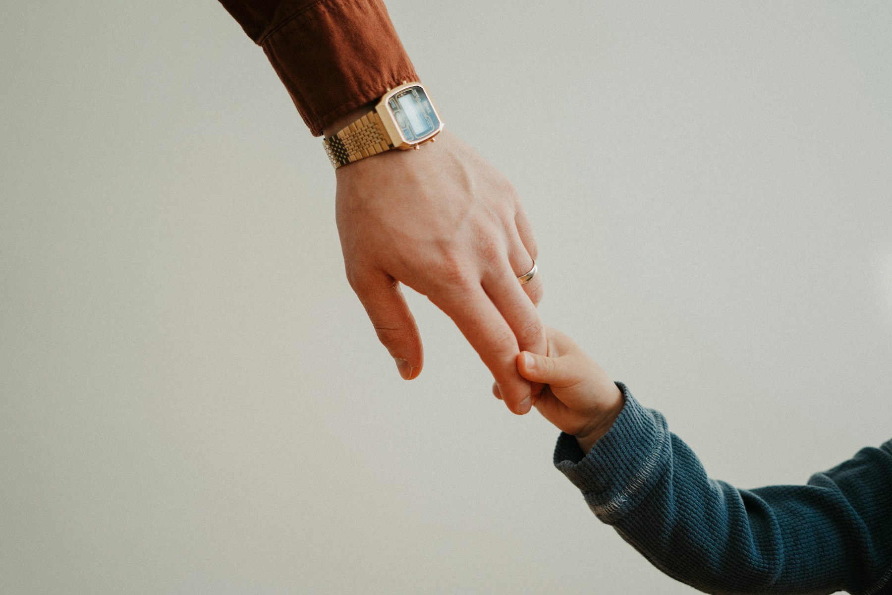 La mano di un adulto accompagna quella di un bambino