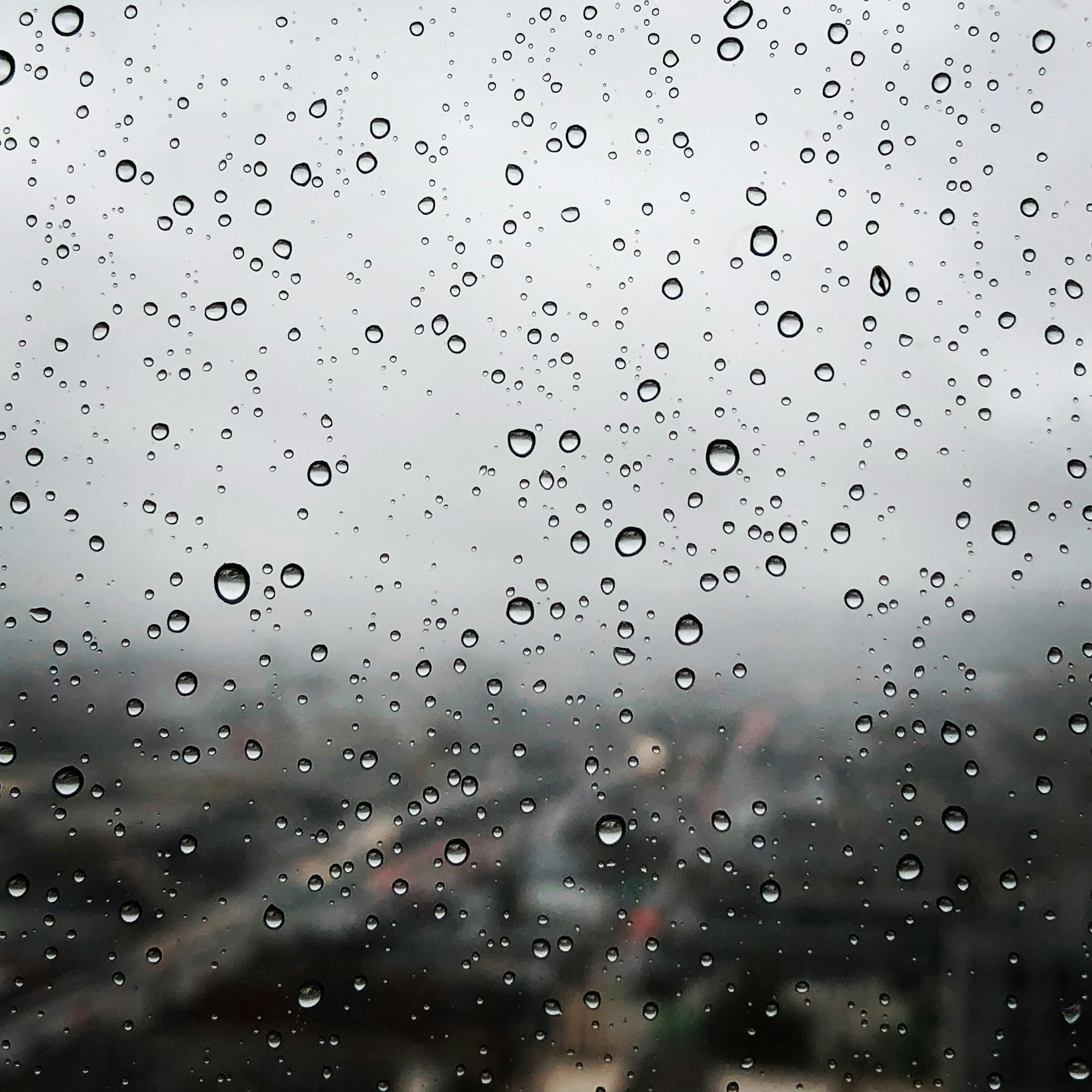 Gocce di pioggia su un vetro davanti alla città
