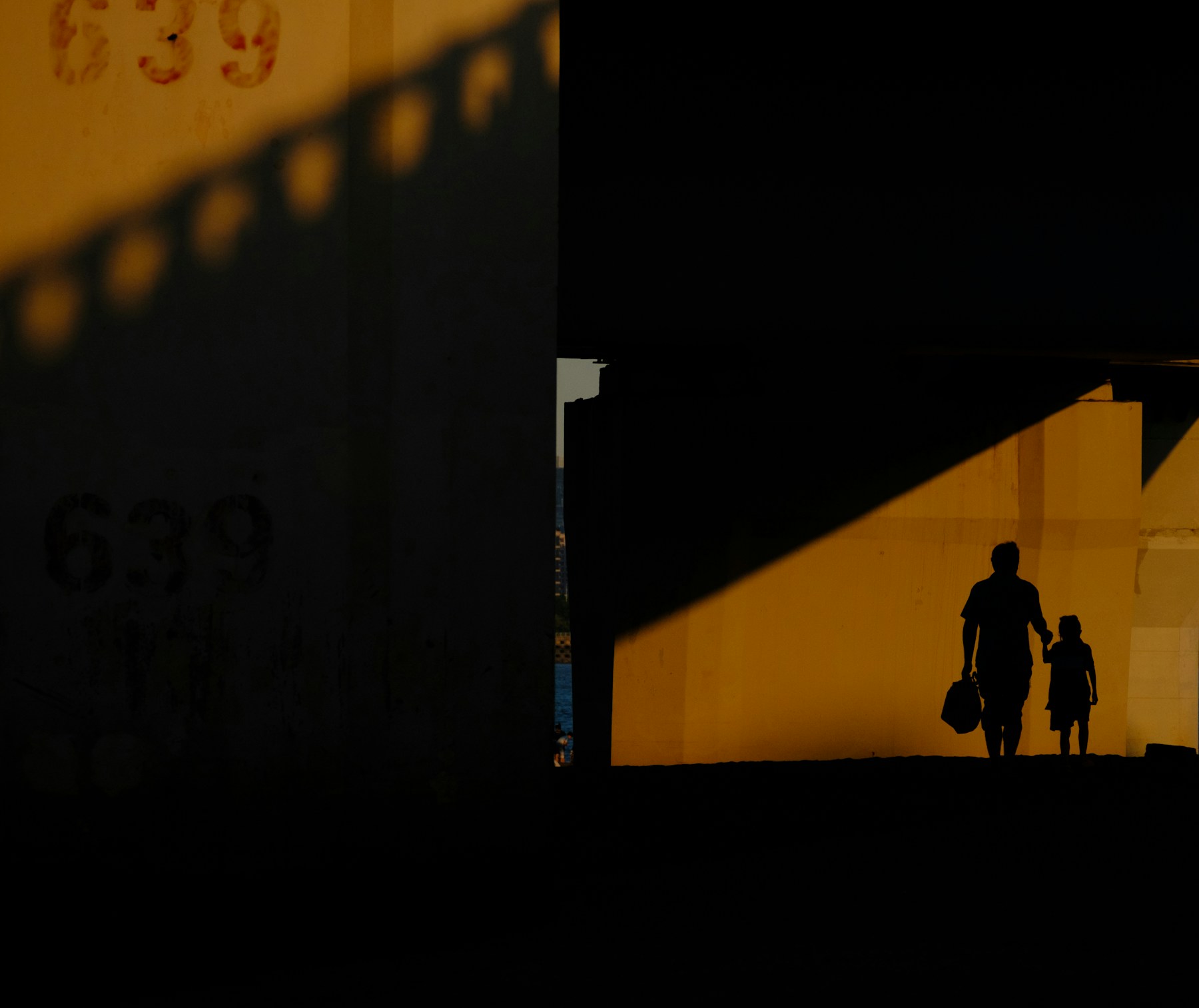 Le sagome di un adulto e di un bambino camminano insieme